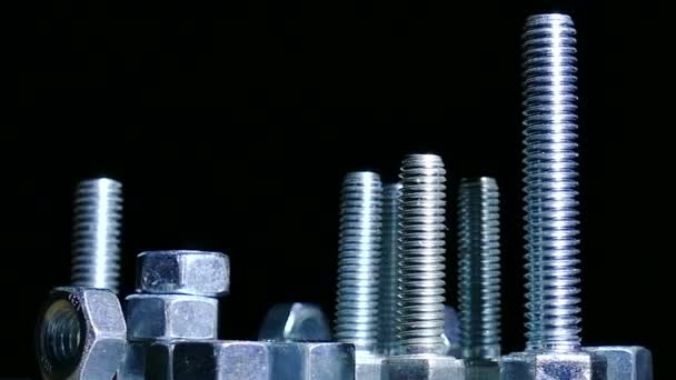 Group of  bolts , nuts rotates against  dark background. 4K   shot — Stock Video