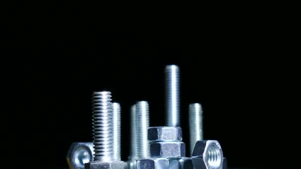 Group of  bolts , nuts rotates against  dark background. 4K   shot — Stock Video