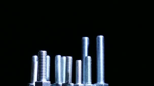 Group of  bolts rotates against  dark background. 4K — Stock Video
