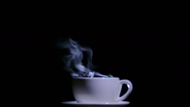 茶または黒の背景に蒸気でコーヒーの白いカップは。4 k 撮影 — ストック動画