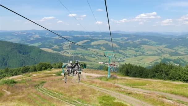 Corde d'ascenseur de ski dans la journée d'été jusqu'à la montagne avec deux hommes cycliste. 4K 3840x2160 . — Video