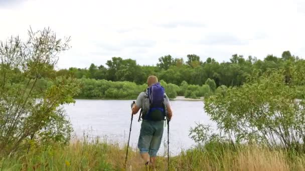 Человек турист на берегу реки выглядит в бинокль. 4K 3840x2160 — стоковое видео