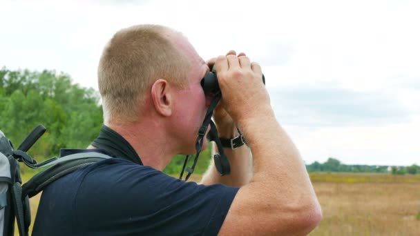 Homem turista olha em binocular no lugar ao ar livre. 4K 3840x2160 — Vídeo de Stock