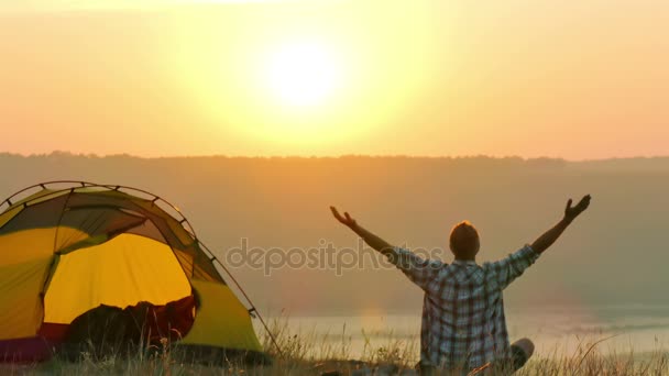 4K Sunrise, lago e homem viajante medita perto da tenda — Vídeo de Stock