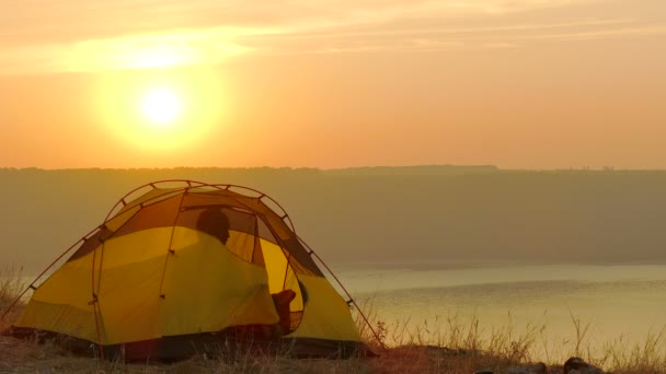 4 k 帐篷，日出和男人的旅行者醒来并获得从帐篷 — 图库视频影像