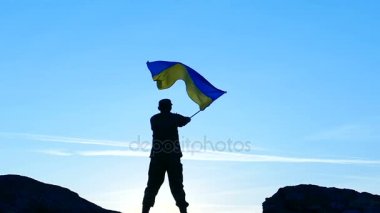  Dalgalar Ukrayna bayrağı mavi gökyüzü karşı asker. Ağır çekim