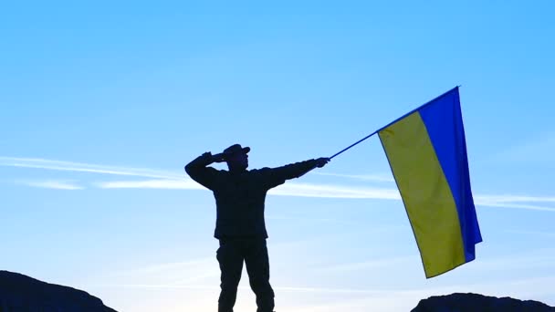 Український прапор і солдата проти синього неба. Повільний підхід фокус — стокове відео