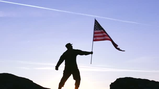 Soldado segurar bandeira americana contra o nascer do sol céu laranja. Movimento lento — Vídeo de Stock