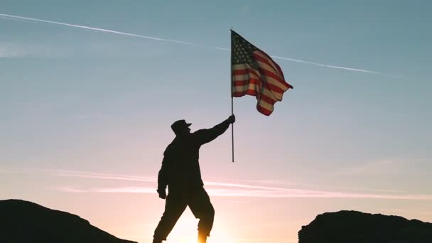 Soldado y bandera americana contra Sunrise Sky. Moción lenta — Vídeos de Stock