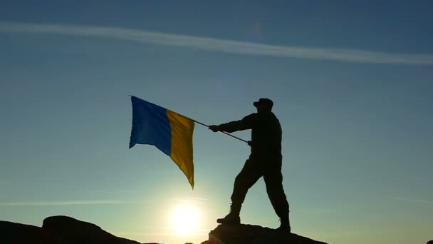 Sylwetka żołnierza, słońce i ukraiński flaga w zwolnionym tempie — Wideo stockowe