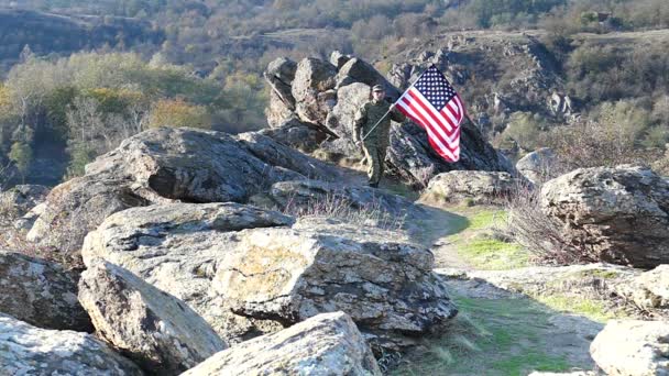 Voják s americkou vlajkou jde na horské dráze. Zpomalený pohyb — Stock video