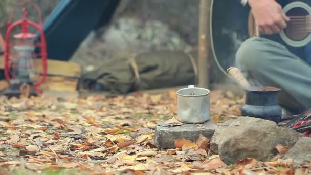 El turista toca la guitarra cerca de la fogata. Vida de viaje de otoño. Vintage disparar . — Vídeos de Stock