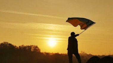 Askerin siluet, Ukrayna bayrağı, gündoğumu zaman yavaş hareket 