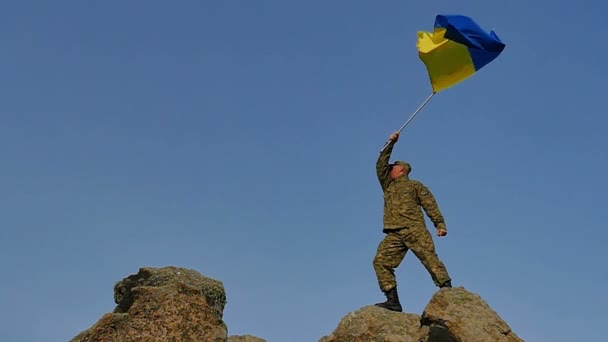 Soldier  waves Ukrainian Flag on mountain top, in Slow Motion — Stock Video