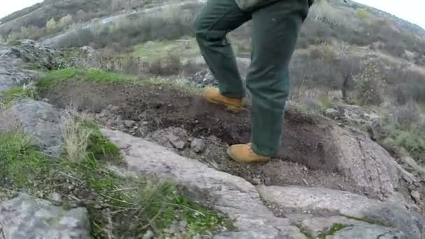 Männerbeine in gelben Stiefeln gehen auf Schanzenjagd. Seitenansicht — Stockvideo