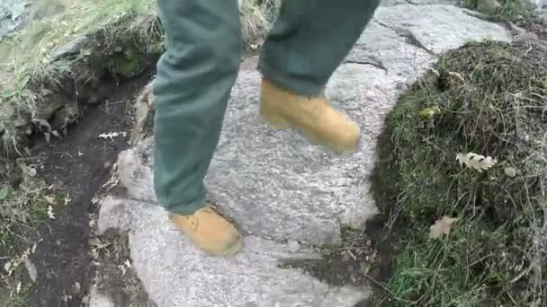 Mužské nohy v žlutých botách jít dolů na trati v hill. — Stock video