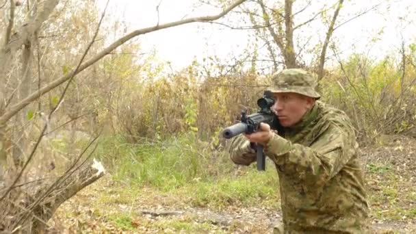 4 k。用自动步枪在秋天树林中移动士兵。稳定的射击 — 图库视频影像