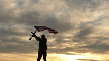 otomatik tüfek dalga Amerikan bayrağı ile siluet asker. Ağır çekim. 