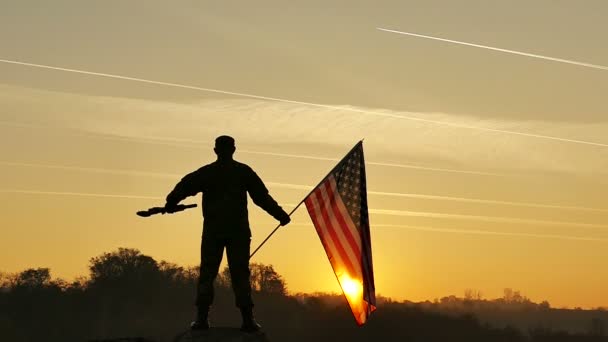 Soldaat omhoog geweer en houd van Amerikaanse vlag tegen hemel. Slow Motion — Stockvideo