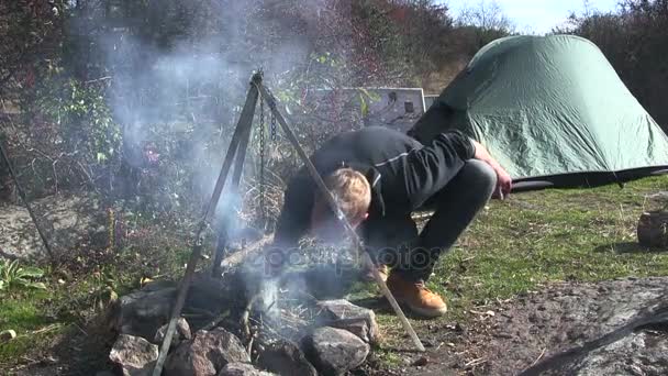 Осінній табір, турист-мандрівник розпалює багаття, удар . — стокове відео