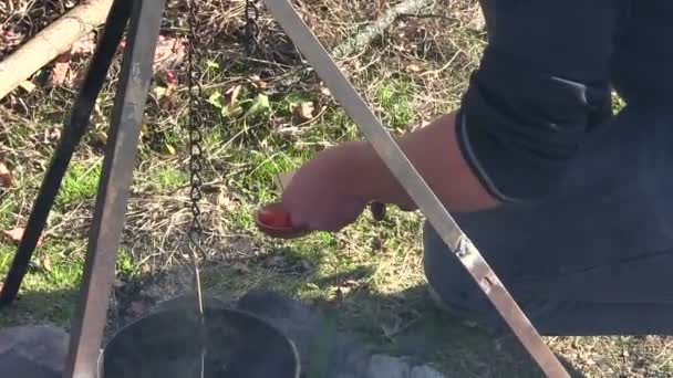 Cocinar comida al aire libre cerca de la hoguera. El hombre llena de especias rojas brillantes — Vídeos de Stock