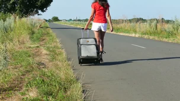 4K. bella donna sexy vado in strada con la valigia. Vista posteriore — Video Stock