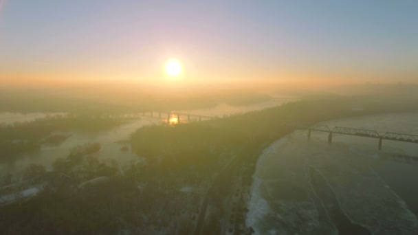 4k letecké. Až po zmrzlém městě řeka, jezero a most v východ slunce, západ slunce. — Stock video