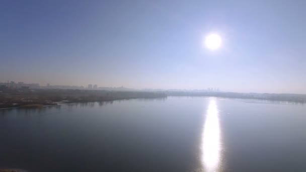 4K Aerial. Зимняя замерзшая река и отражение солнца в воде, задняя муха — стоковое видео