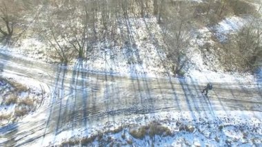   4k hava. Turist kış hayat. Erkek sırt çantası ile dondurulmuş yolda gider. Üstten Görünüm