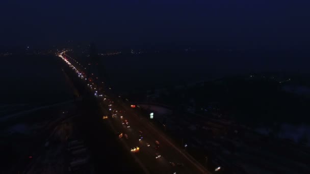 4k luchtfoto. Night City snelweg met autoverkeer en brug over de rivier. Laterale vliegen — Stockvideo