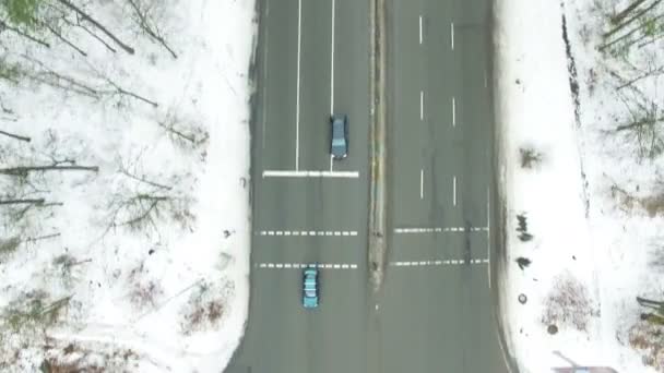 4k letecké. Zimní silnice s auty v lese. Přední pohled shora — Stock video