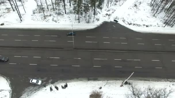 4k luchtfoto. Winter snelweg met auto's in hout. Laterale weergave — Stockvideo