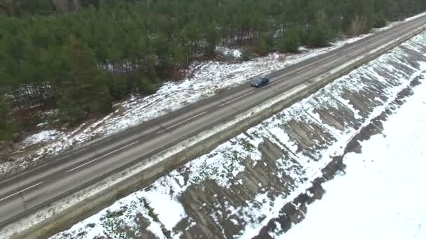 4K Aerial.  Alone  green car on  winter road near  frozen sea and wood — Stock Video