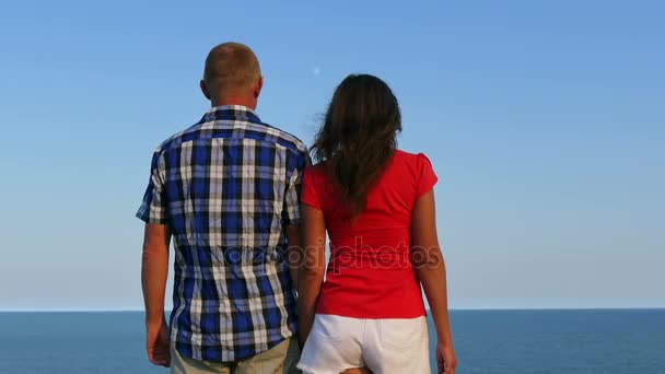 4K. Pareja de pie contra el mar de la mano — Vídeos de Stock