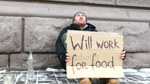 4K. Désespoir de pauvreté Homme affamé adulte avec du carton, dans la rue hivernale de la ville . — Video