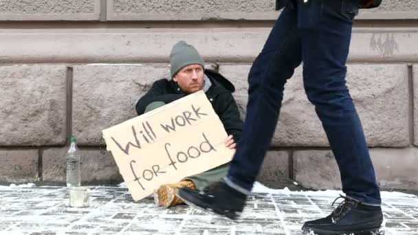 4K. Despair of poverty. Man with cardboard,  and  passerby  gives alms — Stock Video