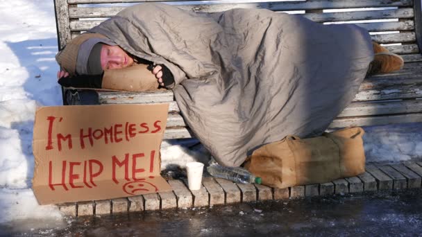 4K.Young homem com papelão no parque da cidade de inverno. Vida de sem-abrigo — Vídeo de Stock