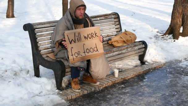 4K. Giovane disoccupato sulla panchina nel parco urbano invernale. Nessun problema di lavoro — Video Stock