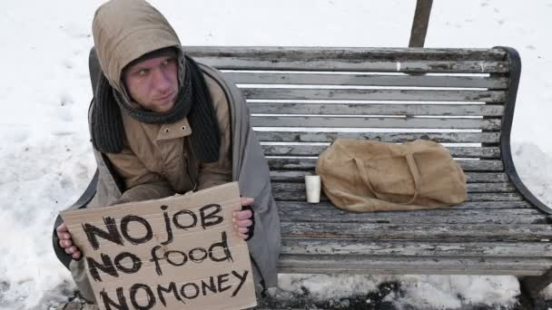 4K.Unemployment άνθρωπος κάθονται στο παγκάκι στο πάρκο της πόλης του χειμώνα. Το πρόβλημα της νεολαίας ζωής — Αρχείο Βίντεο