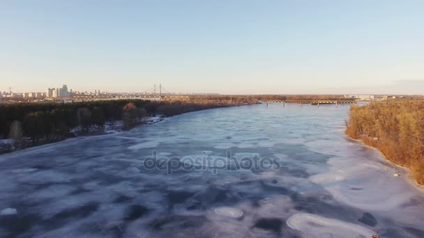 4k antenn. Flyga över vinterfrusen floden i staden, solig dag. — Stockvideo