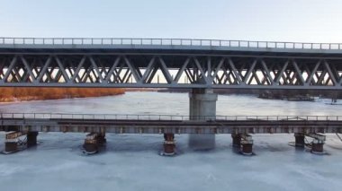  4k hava. Donmuş kış nehir ve eski köprü, yanal uçak, güneşli bir gün.