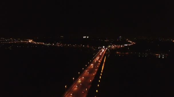 Aérea 4K. Movimiento de coches en el puente a través del río. Escena nocturna — Vídeo de stock