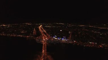  4k hava. Gece uçuşu köprü nehir ve şehir yangınlar aracılığıyla arabalı üzerinde. 