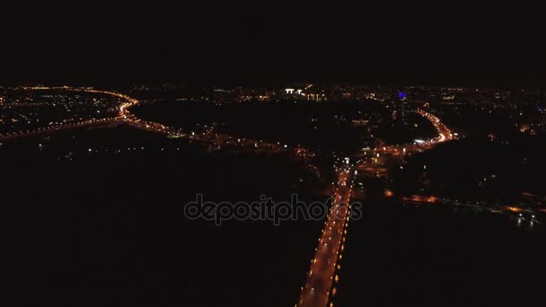 4k luchtfoto. Nachtvlucht over brug met auto's via de rivier en stad branden. — Stockvideo