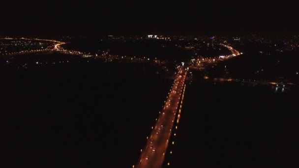4k luchtfoto. Nacht vlucht over brug met auto's via de rivier. De helling van de camera — Stockvideo