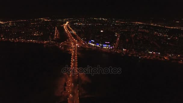 4k luchtfoto. Nachtvlucht over snelweg met auto's en stad branden. De helling van de camera — Stockvideo