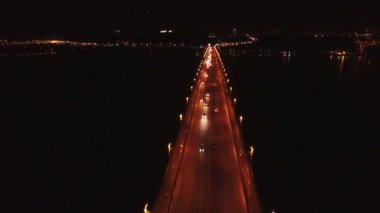  4k hava. Karayolu, araçlarda'nın nehir üzerinde köprü. Gece uçuşu 