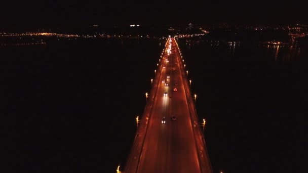 4k luchtfoto. Branden van auto's op de snelweg, brug over de rivier. Nachtvlucht — Stockvideo
