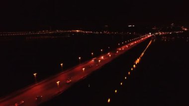  4k hava. Karayolu, araçlarda'nın nehir üzerinde köprü. Gece yarım daire uçuş 