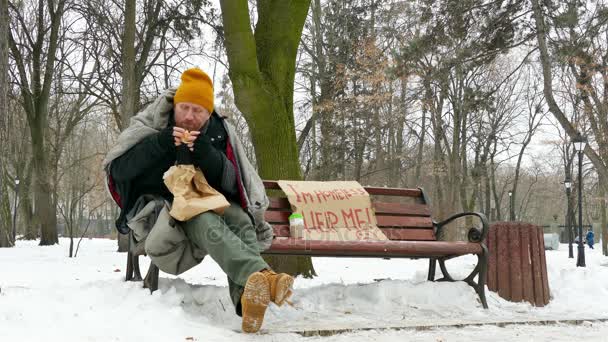 4 k. hemlös hungrig man vintertid stadsparken droppar burger på jorden — Stockvideo